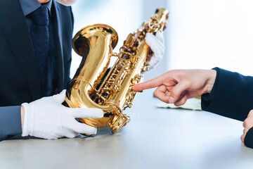 サックスを鑑定するミドルエイジ男性