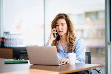 Obraz premium Shot of a blond businesswoman working on a laptop in an office