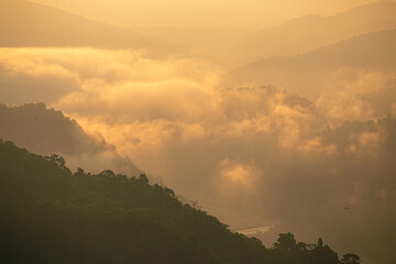 Beautiful high angle view of the sea of ​​mist in the morning amidst the green forest at the hill tribe village of Huai Kup Kab, Mae Taeng, Chiang Mai, Thailand.