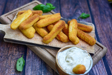  Mozzarella sticks .Italian cheese breaded  oven baked with  fresh basil on wooden background.Italian street food.