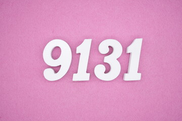 The numbers are made of white painted wood and placed on a pink paper background.