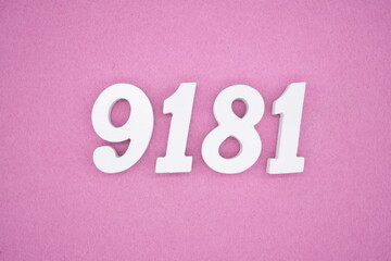 The numbers are made of white painted wood and placed on a pink paper background.