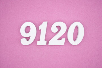 The numbers are made of white painted wood and placed on a pink paper background.