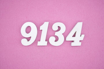 The numbers are made of white painted wood and placed on a pink paper background.