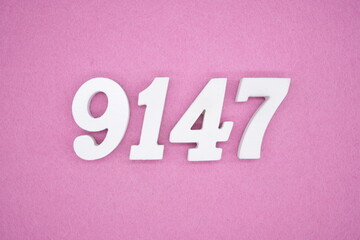 The numbers are made of white painted wood and placed on a pink paper background.
