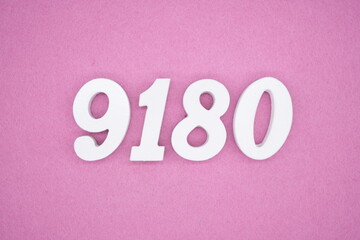 The numbers are made of white painted wood and placed on a pink paper background.