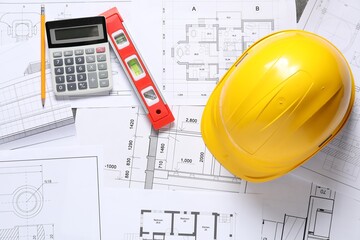 Hard hat, pencil, calculator and building level on different engineering drawings, flat lay