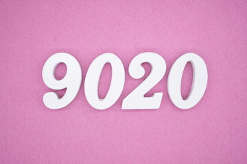 The numbers are made of white painted wood and placed on a pink paper background.