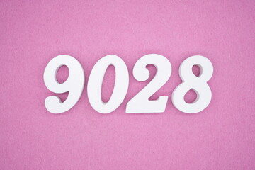 The numbers are made of white painted wood and placed on a pink paper background.