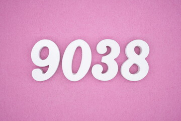 The numbers are made of white painted wood and placed on a pink paper background.