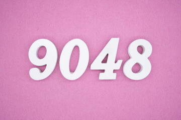 The numbers are made of white painted wood and placed on a pink paper background.