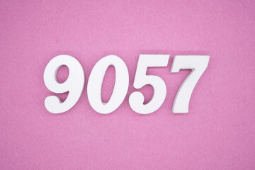 The numbers are made of white painted wood and placed on a pink paper background.