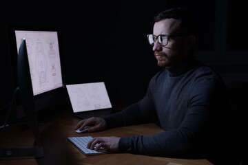 Engineer working with computer at table in office