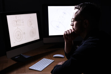 Engineer working with digital drawing at table in office