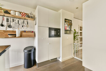 A contemporary kitchen showcasing sleek cabinetry, stylish shelves, and practical storage solutions, creating a functional and aesthetic cooking space.