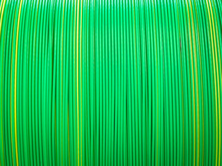 Obraz premium Vivid green and yellow plastic coated cables tightly coiled, showcasing a symmetrical and colorful pattern.
