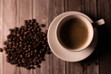 A cup of coffee with foam. View from above. A cup of coffee and coffee beans
