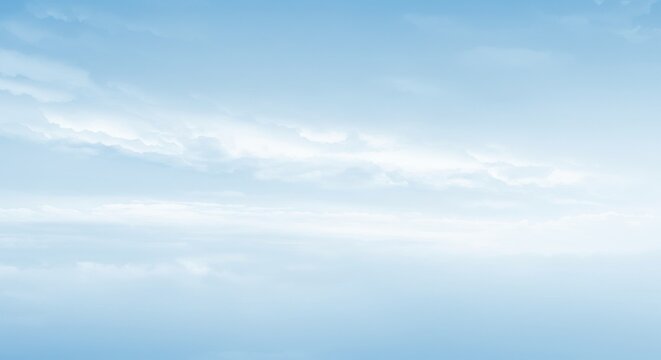 A serene view of a light blue sky with soft white clouds drifting gently across the horizon line
