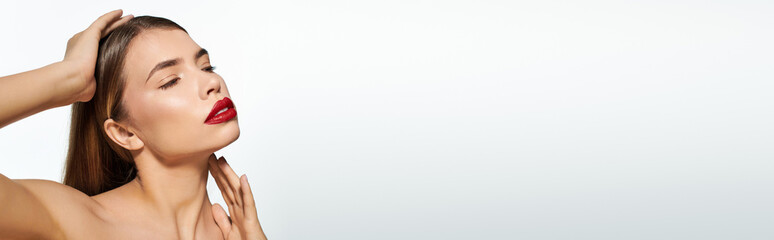 Naklejka premium Young woman exudes confidence and beauty with stylish pose against a minimalist background