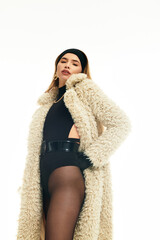 Fashion forward woman in stylish outfit poses confidently in soft outerwear