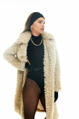Stylish young woman in a chic fur coat showcasing a fashionable outfit in a modern setting