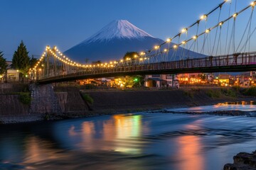 Obraz premium Stunning twilight view of Mount Fuji with illuminated bridge and reflective river, showcasing Japan's natural beauty and tranquility.