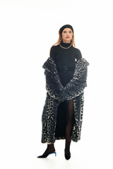 Stylish young woman in leopard print coat poses confidently in a modern fashion setting