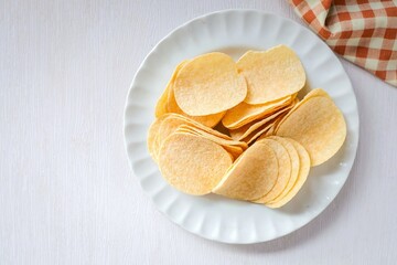 Potato chips in white plate on white background	