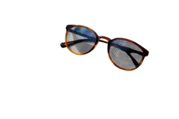 Stylish sunglasses resting on a beach towel warm sunlight sandy beach background summer vacation