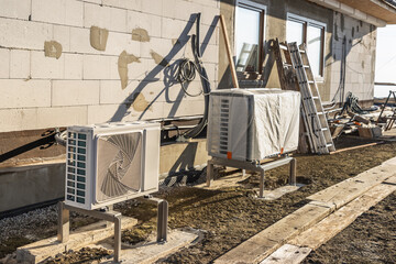 Obraz premium Air source heat pumps installed outside of new and modern city house under construction, green renewable energy concept of heat pump