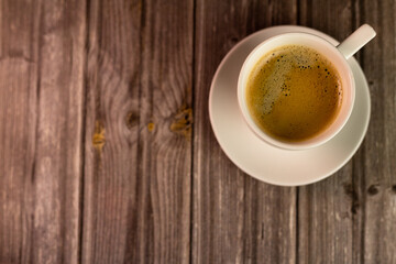 Coffee on a wooden table. Background with a cup of coffee. View from above.