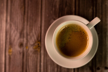 Morning coffee. View from above. Cup of coffee on a wooden table