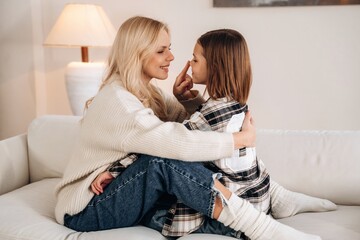 Side view, embracing each other. Mother and daughter are together in domestic room