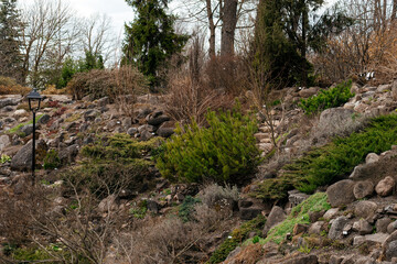 A tranquil botanical garden with winding pathways, lush greenery, and natural rock formations,...