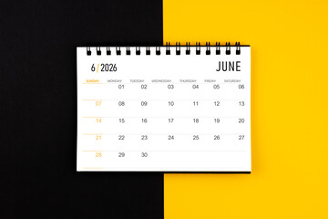 June 2026 desk calendar on black and yellow background, Flat lay.