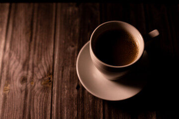 A cup of coffee on a wooden table. View from above. Coffee with foam