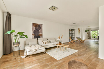 A spacious and elegantly designed modern living room featuring stylish furniture, natural light,...