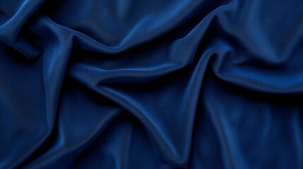Fototapeta premium A close-up view of elegant, draped dark blue fabric, showcasing its soft texture and rich color.
