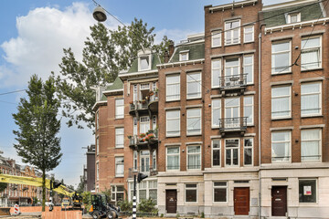 A picturesque view of classic Amsterdam buildings juxtaposed with lush trees, showcasing urban beauty and nature's touch in the heart of the city.