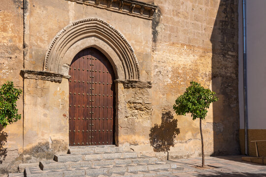 Ancient wooden door with metal studs and stone steps in cordoba, andalusia, a testament to spain's rich architectural heritage