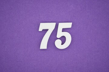 The numbers are made of white painted wood placed on a purple paper background.