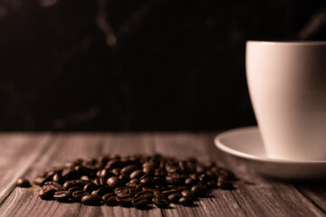 Coffee beans, white cup on dark background. Cup of coffee