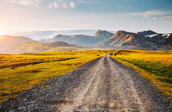 Typical Icelandic terrain with a road stretching into remote mountain ranges. Location place southern Iceland, Europe.