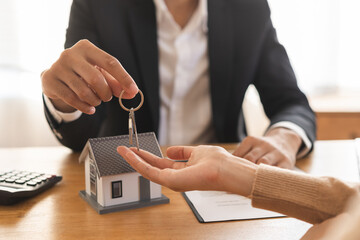 Close up agent giving a key to new owner or tenant, client after signed signature contract rental...