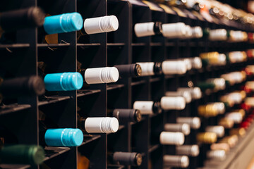 Wine bottles in vertical shot stacked on racks shot with limited depth of field.