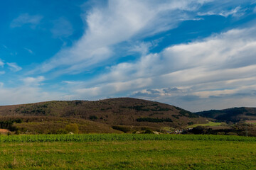 Scenic view of lush hills and blue sky during the afternoon in a quiet countryside landscape