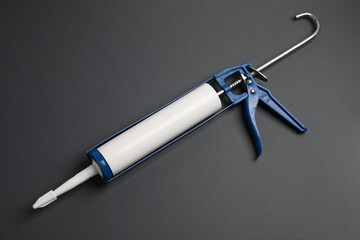 One glue gun on gray background, top view