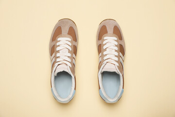 Pair of stylish sneakers on beige background, flat lay. Casual shoes