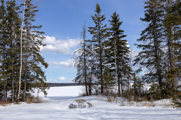 Tranquil solitude with lonely picnic table at Narrows Beach in Prince Albert National Park, Canada in late March