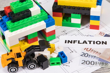 Houses made of toy blocks, house plan, euro banknotes with inscription inflation. High prices building or purchase home